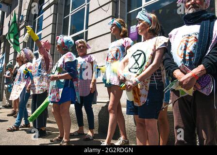 Falmouth, Cornwall, Großbritannien 2021 12. Juni ‘Aussterbungsrebellion marschiert aus Protest gegen die „Greenwashing“-Politik von Wirtschaft und Regierung beim G7-Gipfel. Die roten Rebellen führten den marsch durch das Stadtzentrum, zusammen mit den Ärzten von XR und schmutzigen Wäschern, und endeten am Medienzentrum. Stockfoto