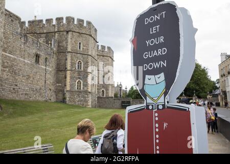 Windsor, Großbritannien. Juni 2021. Ein Schild vor Windsor Castle mit einem Bild eines Wachmanns warnt die Besucher, Sicherheitsanweisungen zu befolgen, die die Ausbreitung des Coronavirus verhindern sollen. Obwohl Surge-Tests in den nahe gelegenen Ländern Slough, Bracknell und Wokingham eingeführt wurden, liegen die COVID-19-Infektionen im Royal Borough of Windsor and Maidenhead noch immer deutlich unter dem nationalen Durchschnitt. Kredit: Mark Kerrison/Alamy Live Nachrichten Stockfoto