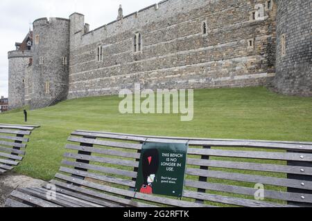 Windsor, Großbritannien. Juni 2021. Ein Schild vor dem Schloss Windsor mit dem Bild eines Wachmanns warnt die Besucher davor, dass eine Bank nicht mehr im Einsatz ist, um die Ausbreitung des Coronavirus zu verhindern. Obwohl Surge-Tests in den nahe gelegenen Ländern Slough, Bracknell und Wokingham eingeführt wurden, liegen die COVID-19-Infektionen im Royal Borough of Windsor and Maidenhead noch immer deutlich unter dem nationalen Durchschnitt. Kredit: Mark Kerrison/Alamy Live Nachrichten Stockfoto