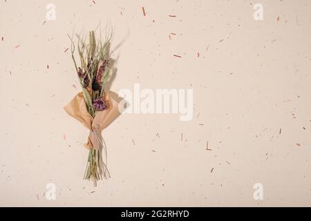 Bouquet von getrockneten Blumen auf handgefertigten Papier Hintergrund. Flach liegend, Draufsicht. Speicherplatz kopieren. Stockfoto