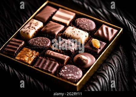 Schweizer Pralinen in Geschenkbox, verschiedene Luxus-Pralinen aus dunkler und milcher Bio-Schokolade in der Schweizer Chocolaterie, süße Dessertspeisen wie Stockfoto