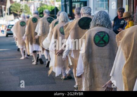 Falmouth, Cornwall, Großbritannien 12. Juni 2021 Extinction Rebellion Demonstranten kleiden sich als G7-Gipfel der „Büßer“. Die Büßer basieren auf der mittelalterlichen Idee der Sühne für Übertretungen gegen die Gemeinschaft, sie tragen die Verbrechen der heutigen Welt in ihre eigenen. Stockfoto