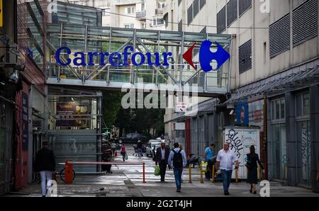 Bukarest, Rumänien - 08. Juni 2021: Das Logo des französischen multinationalen Einzelhändlers Carrefour ist auf der erhöhten Fußgängerbrücke zwischen dem Geschäft A zu sehen Stockfoto