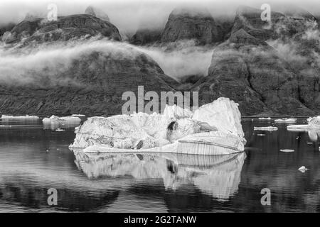 Schwarz-Weiß-Foto von schwimmenden Eisbergen am Abend, Grönland, Dänemark, Scoresby Sund, Kangertittivaq, Grönland, Dänemark Stockfoto