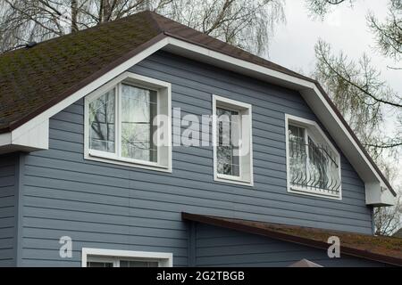 Landhaus außerhalb der Stadt. Fenster für Wohngebäude. Gemütliche Unterkunft weit weg von der Autobahn. Dach eines Landhauses. Stockfoto