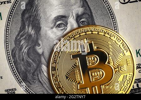 Bitcoin vs. US-Dollar, Goldmünze auf 100-Dollar-Schein. Digitale Krypto-Währung Bitcoin und Franklin-Porträt auf Geldschein. Konzept der Bank, Bitcoin Stockfoto