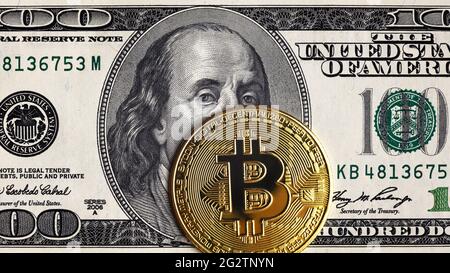 Bitcoin vs. US-Dollar, Goldbitmünzen auf 100-Dollar-Schein. Digitale Krypto-Währung Bitcoin und Franklin-Porträt auf Geldschein. Konzept der Bank, Bitcoin Stockfoto