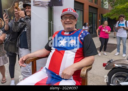 NEW YORK, NY – 12. JUNI: Ein Mann mit einem Aufkleber mit der Aufschrift „Ich habe früh gestimmt“ sitzt am 12. Juni 2021 vor einem Wahllokal im Campos Plaza Community Center in New York City. Kredit: Ron Adar/Alamy Live Nachrichten Stockfoto