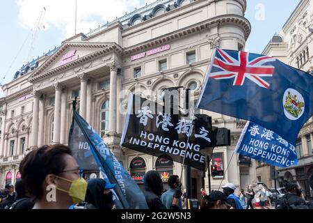 Demonstranten winken während der Demonstration Flaggen.am 12. Juni 2019 gingen Demonstranten in Hongkong auf die Straße und forderten die Rücknahme des chinesischen Auslieferungsgesetzes, wurden aber mit brutaler Polizei getroffen. Unter der Führung der Hongkonger Freiheit versammelten sich die Hongkonger Diaspora in London und marschierten zur Erinnerung an den Protest von 2019, um ihre Solidarität mit Freiheitskämpfern in Hongkong gegen die politische Unterdrückung durch die Kommunistische Partei Chinas auszudrücken. Der marsch begann am Marble Arch, ging durch den Oxford Circus und China Town und endete schließlich am Trafalgar Square. Stockfoto