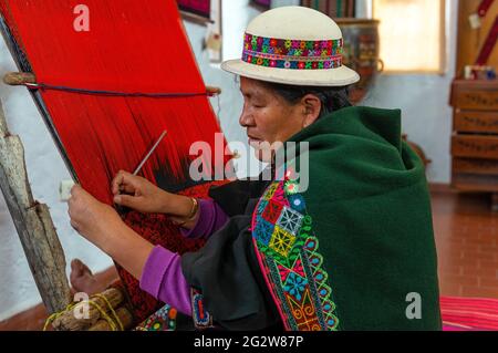 Bolivianische ältere indigene Frau in traditioneller Kleidung, zeigt traditionelle Jalq'a Textilweberei, Sucre, Bolivien. Stockfoto