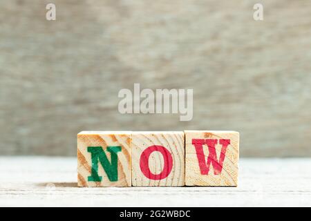 Buchstabenblock in Wort jetzt auf Holzhintergrund Stockfoto