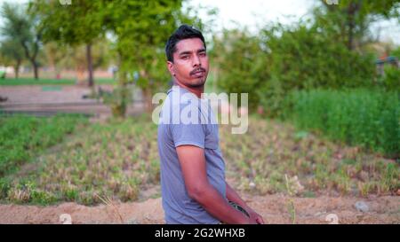 Gesunder junger Mann, der Stretching-Übungen auf grünem Gras im Park macht. Konzept des Yoga-Tages Stockfoto