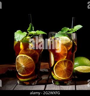 Frisch zubereitetes Longdrink Cuba Libre Cocktail auf dunklem Hintergrund. Vorderansicht Stockfoto