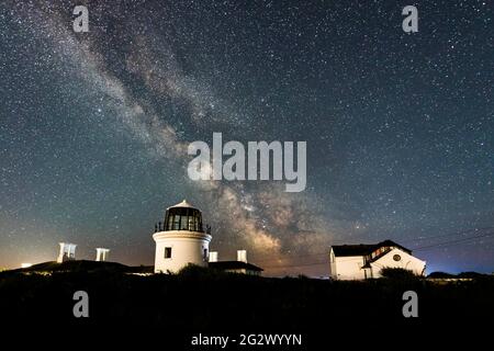 Portland Bill, Dorset, Großbritannien. Juni 2021. Wetter in Großbritannien. Die Milchstraße leuchtet hell am klaren Nachthimmel über dem höheren Leuchtturm bei Portland Bill in Dorset. Bildnachweis: Graham Hunt/Alamy Live News Stockfoto