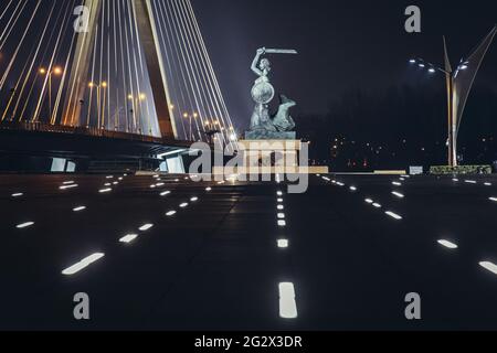 Abendansicht der Statue der Meerjungfrau auf den Vistulan Boulevards und der Swietokrzyski Brücke über dem Ufer der Weichsel in Warschau, Polen Stockfoto