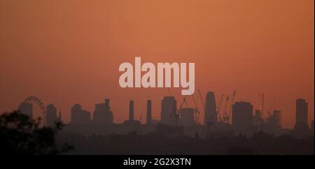 Skyline von London mit Baukräne und dem London Eye bei Sonnenaufgang am 13. Juni 2021, von Wimbledon im Südwesten Londons, Großbritannien aus gesehen Stockfoto