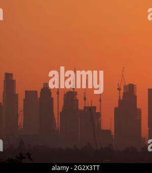 Skyline der Stadt London mit Baukräne bei Sonnenaufgang am 13. Juni 2021, von Wimbledon im Südwesten Londons, Großbritannien aus gesehen Stockfoto