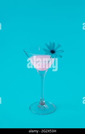 Pink Neon Drink Cocktail mit weißen Blumen und alle von blauem Licht beleuchtet. Futuristisches Partykonzept mit minimaler Komposition. Stockfoto