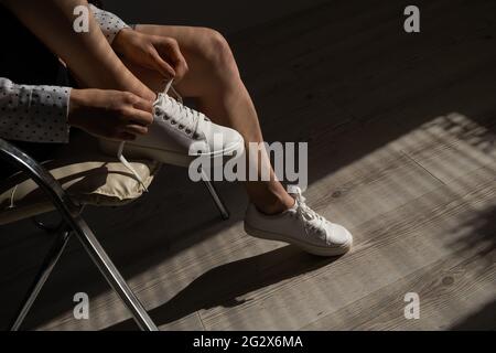 Frau zog neue weiße Leder-Sneakers an Stockfoto