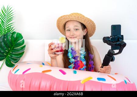 Die kleine Bloggerin imitiert den Urlaub zu Hause in Quarantäne und nimmt Videos am Telefon auf. Inlandstourismus. Coronavirus-Situation in der Tourismusindustrie. Q Stockfoto