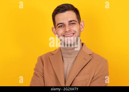 Isoliertes Porträt eines jungen Mannes im Mantel Stockfoto