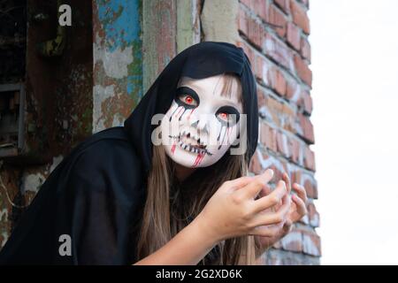 Zombie kriecht aus dem Dach. Die Hände greifen nach der Kamera. Halloween und Tag der Toten Konzept. Die roten Augen eines Vampirs. Stockfoto