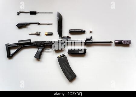 Zerlegtes Maschinengewehr auf grauem Hintergrund. Isoliert. Details von Feuerwaffen in zerlegtem Zustand. Stockfoto