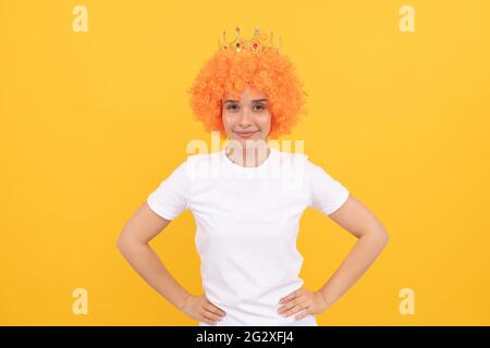 Fröhliche, freaky egoistische Frau in lockiger Clown Perücke und Königskrone für Party, Freude Stockfoto