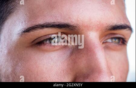 Nahaufnahme von grünen Augen eines hübschen jungen Mannes Stockfoto