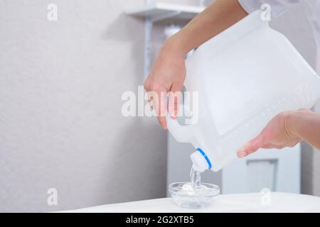 Kosmetologe pooring transparentes Gel aus einer großen Flasche Stockfoto