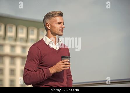 Angenehme Momente. Ruhe. Kaffeepause. Unterwegs Kaffee trinken. Entspannen Sie sich und tanken Sie neue Kraft. Schöner Kerl halten Kaffee Tasse Himmel Hintergrund Kopie Raum Stockfoto