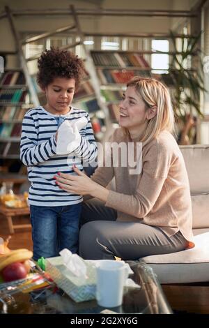 Glücklich kaukasischen Kindermädchen Babysitting afro amerikanischen Jungen zu Hause Stockfoto