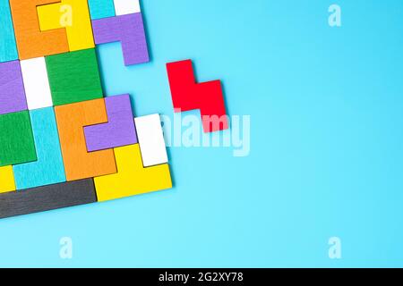 Bunte Holz Puzzle-Stücke auf blauem Hintergrund, geometrische Form Block. Konzepte des logischen Denkens, Rätsel, Lösungen, rational, Strategie, Welt l Stockfoto