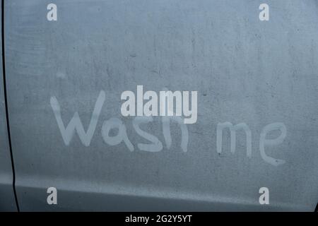 Finger Lettering waschen mich in einem schmutzigen blauen Auto. Stockfoto