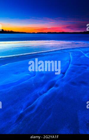 Eisformationen und farbenfroher Winterhimmel bei Sonnenaufgang im See Vansjø in Østfold, Norwegen, Skandinavien. Stockfoto