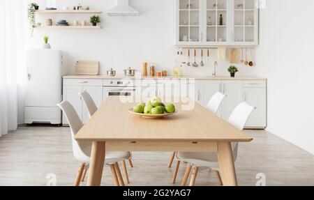 Moderne skandinavische Küche Interieur mit verschiedenen Accessoires. Weiße Küchenmöbel mit Haushaltsgegenständen auf Regalen Stockfoto