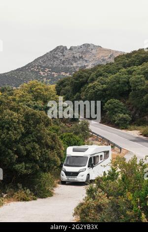 Weißes Wohnmobil auf einer Straße durch einen Wald Stockfoto