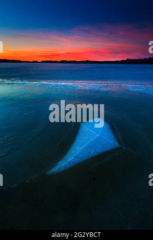 Eisformationen und farbenfroher Winterhimmel bei Sonnenaufgang im See Vansjø in Østfold, Norwegen, Skandinavien. Stockfoto