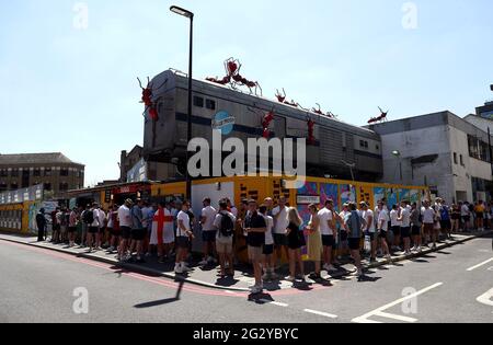 England-Fans stehen vor dem Essig Yard in London Schlange, während sie warten, um das UEFA Euro 2020-Spiel der Gruppe D zwischen England und Kroatien im Wembley-Stadion zu sehen. Bilddatum: Sonntag, 13. Juni 2021. Stockfoto
