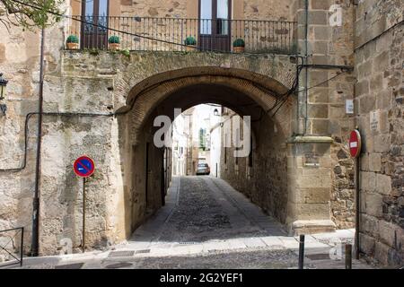 Caceres, Spanien. Die Puerta de Coria (Coria-Tor), eine Straße mit einem Bogen in der Altstadt von Monumental, die zum Weltkulturerbe gehört Stockfoto