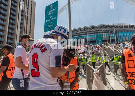 Wembley Stadium, Wembley Park, Großbritannien. Juni 2021. Zuschauer mit schützenden Gesichtsbezügen zeigen ihre negativen Covid Lateral Flow-Testergebnisse vor der Aufnahme ins Wembley Stadium. Im Wembley-Stadion findet heute Nachmittag das erste Spiel der UEFA-Fußball-Europameisterschaft statt, wenn England Kroatien spielt. Amanda Rose/Alamy Live News Stockfoto