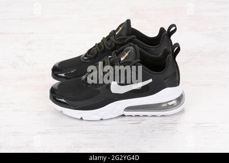 BURGAS, BULGARIEN - 8. DEZEMBER 2020: Nike Air MAX 270 REACT Damenschuhe - Sneaker in Schwarz auf weißem Holzhintergrund. Nike ist ein globales Sportklumpen Stockfoto