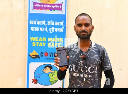 Beawar, Rajasthan, Indien, 13. Juni 2021: Jaisingh Rathore, Ein Bewohner, der nach Online-Betrug in einem COVID-19-Impfzentrum in Beawar eine Co-WIN-Anwendung auf seinem Handy vorführt. Jaisingh erhielt keinen Impfstoff, sondern eine App, die zeigt, dass eine Person in Sikar von Jaisinghs Handynummer geimpft wurde. Kredit: Sumit-Samarwat/Alamy Live Nachrichten Stockfoto