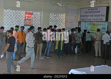 Beawar, Rajasthan, Indien, 13. Juni 2021: Passagiere, Halten Sie sich nicht an die sozialen Distanzierungsnormen und stellen Sie sich während der Sperrung am Wochenende wegen einer COVID-19-Pandemie in Beawar an einem Ticketschalter am Bahnhof in eine Warteschlange. Kredit: Sumit-Samarwat/Alamy Live Nachrichten Stockfoto