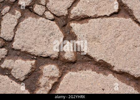 Risse in der Oberfläche des Pflasters einer verwitterten Straße Stockfoto