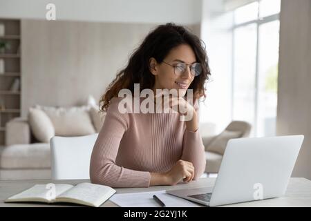 Hispanische Frau arbeitet am Computer online Notizen machen Stockfoto