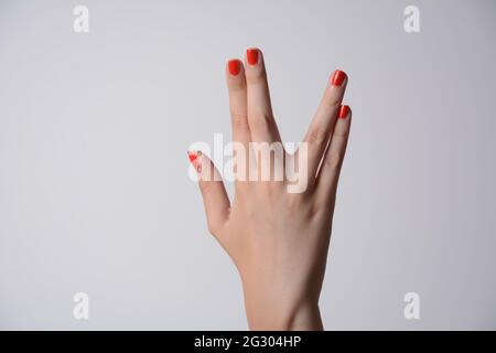 Eine Mädchenhand, die den vulkanischen Gruß auf weißem Hintergrund macht. Vulkanische Hand grüßen dagegen. Spock Hand. Alpha. Stockfoto