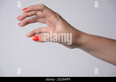 Hand eines Mädchens, das versucht, etwas zu erreichen oder zu greifen. Fling, Touch-Schild. Isoliert auf weißem Hintergrund. Stockfoto