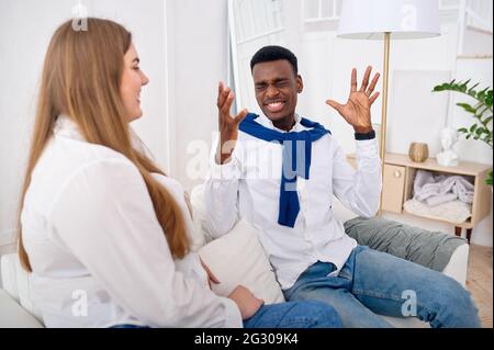 Glückliches Liebespaar, das zu Hause auf dem Sofa spricht Stockfoto