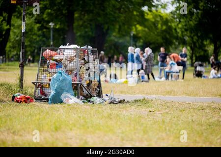 Berlin, Deutschland. Juni 2021. Ein voller Mülleimer im Volkspark Friedrichshain. In mehreren Berliner Parks haben große Partys in der Nacht bis zum Samstag die Polizei auf den Plan gerufen. Auch wegen Verletzungen der Hygieneanforderungen bei der Pandemie hat die Polizei einige Grünflächen geräumt, teilte die Behörde am Samstag mit. Quelle: Christoph Soeder/dpa/Alamy Live News Stockfoto